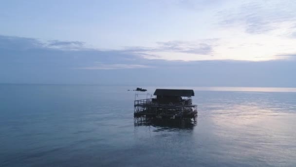 Hermoso bungalow de madera rodeado de impresionantes aguas del océano. Le dispararon. Impresionante vista al mar con cielo azul y pequeño bungalow . — Vídeo de stock