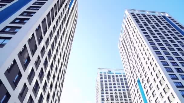 Bottom view of new residential high-rise buildings with blue sky. Urban environment. Frame. Newest residential complexes with an eco-friendly environment — Stock Video
