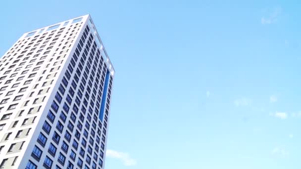 Blick von unten auf neue Wohnhochhäuser mit blauem Himmel. städtisches Umfeld. Rahmen. Neueste Wohnanlagen mit einer umweltfreundlichen Umgebung — Stockvideo