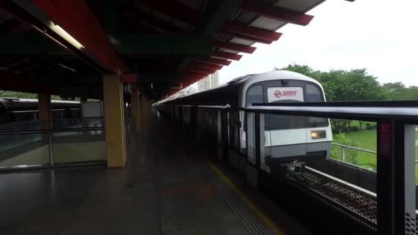 En Mrt tåget i Singapore på stationen på gröna träd bakgrund. Skott. Singapore massa snabba tåg Mrt vid stationen. — Stockvideo