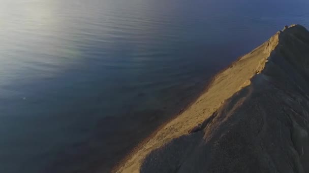 曇りの青い空と海の背景にフィールドとチリの海岸線を眺め.ショット。海、農場、海岸沿いの岩によって支配される驚くほどの風景. — ストック動画