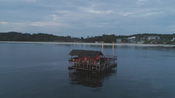 Plage de sable blanc, palmiers et bungalow d'eau. Fusillade. Aérien pour bungalow sur l'eau avec des marches dans un incroyable lagon vert — Video