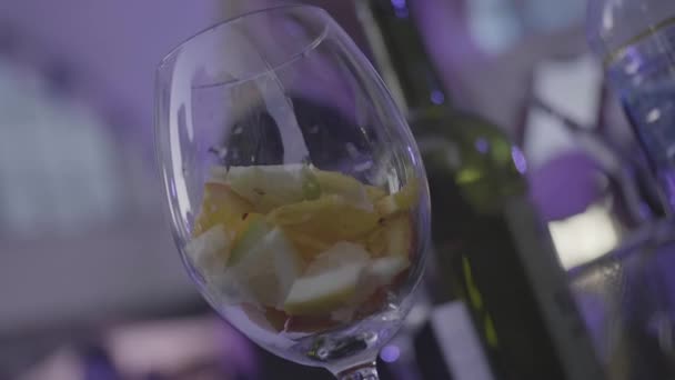 Bicchiere vuoto con fette di lime, arancia, limone pronte per la preparazione del cocktail. Cornice. Bicchiere di vino vuoto con agrumi sul tavolo . — Video Stock