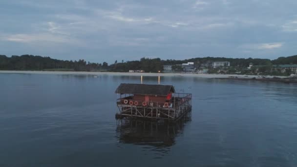 Plage de sable blanc, palmiers et bungalow d'eau. Fusillade. Aérien pour bungalow sur l'eau avec des marches dans un incroyable lagon vert — Video