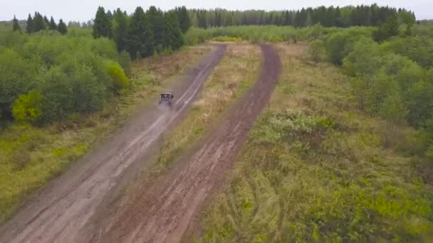 Vue de la conduite de VUS sur route de boue. Clip. Vue de dessus du passage à la vitesse du VUS sur la route rurale sale dans la campagne — Video