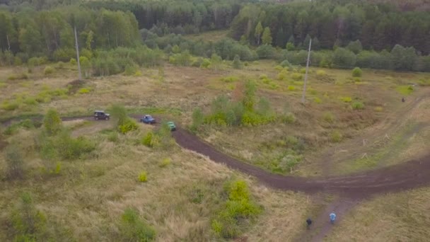 Blick auf Geländewagen, die auf Pfützen fahren. Clip. Blick von oben auf überwindende Pfützen von Geländewagen bei Matsch-Rennen. Jeep-Rennen — Stockvideo