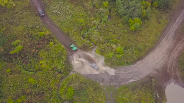 Zobacz samochody typu SUV, jazda na kałuży. Klip. Widok z góry wieńczących kałuże SUV-y na błotnym rasom. Wyścigowe Jeep — Wideo stockowe