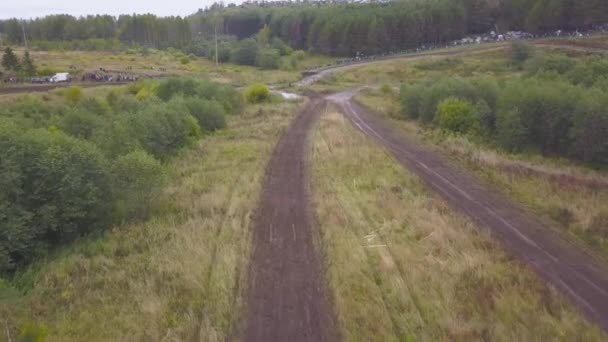 国の道路で運転する Suv の平面図です クリップ 汚い地面に田舎の森林に覆われた地域でオフロード レース — ストック動画