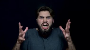 Sakallı bir genç adam kızgın. Kızgın genç adam dişlerini öfkeyle hırıltı gösterilen sakallı. İnsan yüz ifadeleri ve duygular
