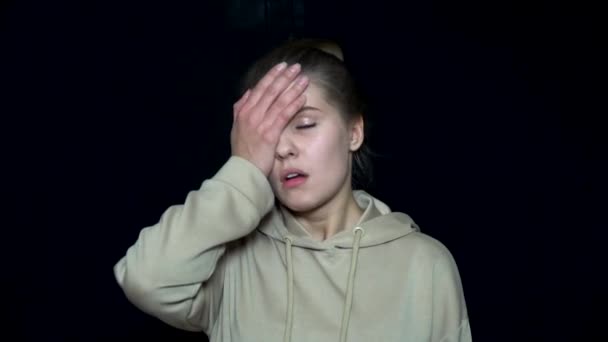 Müde junge Frau, die Gesicht mit der Hand bedeckt. unglückliche und irritierte junge Frau. menschliche Mimik und Emotionen — Stockvideo