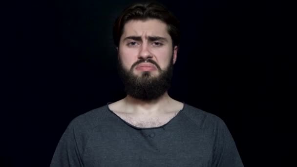 Férfi szakállal sajnos összevonta a szemöldökét, és ideges. Fiatal férfi szakállal úgy néz ki, szomorú és a sértett megoldottad. Emberi arc-kifejezések és érzelmek — Stock videók
