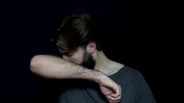 Человек с бородой воняет потом. Молодой человек испытывает отвращение от вони подмышки. неприятный запах, потребность в антиперспирантах — стоковое видео