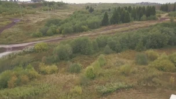 Extremo Motorsport de SUVs dirigindo na estrada do país. Clipe. Vista superior da pista de corrida para SUVs na floresta. SUV passeios a velocidade em linha reta estrada rural na floresta — Vídeo de Stock