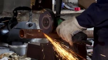 Fabrika ve fırlatma açısı değirmeni kullanarak alt kıvılcım. Koruyucu üniforma ve metal kesme açısı öğütücü ile giyen adam.