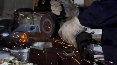 Fabrika ve fırlatma açısı değirmeni kullanarak alt kıvılcım. Çerçeve. Koruyucu üniforma ve metal kesme açısı öğütücü ile giyen adam.