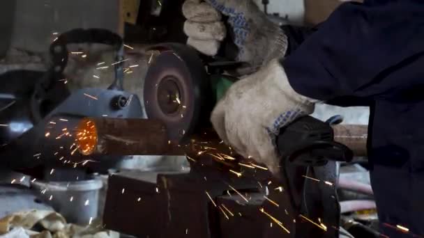 Trabalhador usando moedor de ângulo na fábrica e jogando faíscas. Moldura. Homem vestindo uniforme de proteção e corte de metal com moedor de ângulo . — Vídeo de Stock