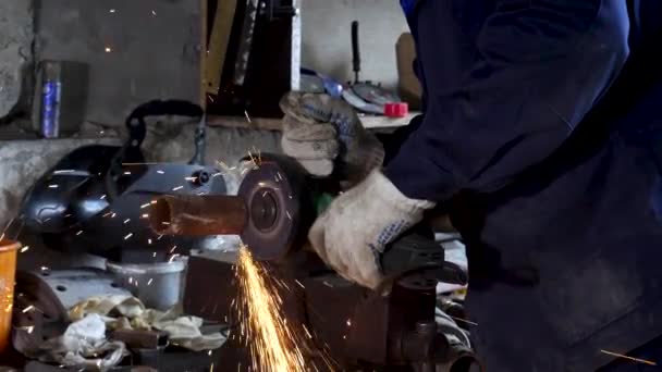 Trabajador usando amoladora angular en fábrica y lanzando chispas. Una trampa. Hombre con uniforme protector y corte de metal con amoladora angular . — Vídeos de Stock