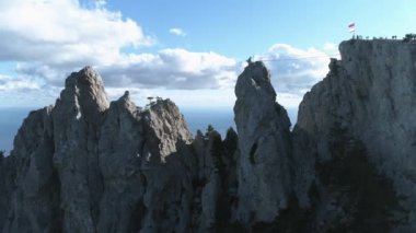 Denizin üzerinde bir dağın tepesinde duran insanlar grubudur. Vurdu. Onlar ulusal bayrak dikildi