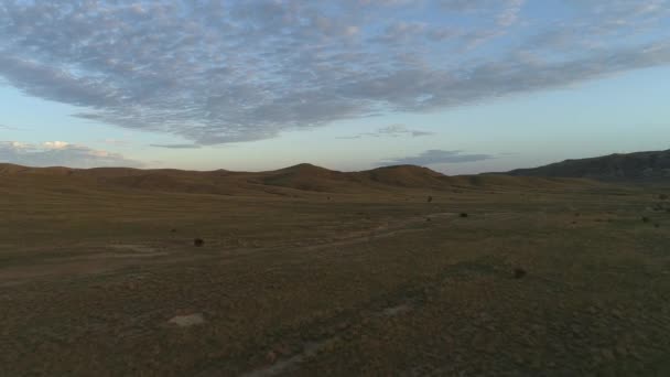Vanligt landskap med morgon ängen mot kullar och blå himmel. Skott. Vacker utsikt på en vanlig morgon. — Stockvideo