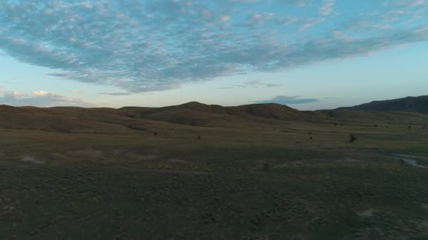 Vanligt landskap med morgon ängen mot kullar och blå himmel. Skott. Vacker utsikt på en vanlig morgon. — Stockvideo