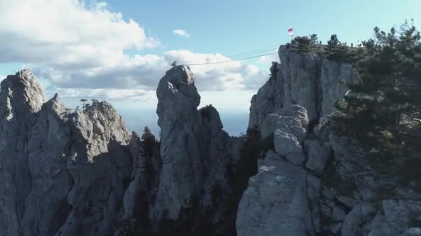 Group of people standing on top of a mountain over the sea. Shot. They planted the national flag — Stock Video