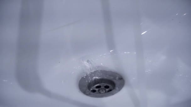 Κοντινό πλάνο της διαρροής νεροχύτη με νερό. Καθαρίζονται μεταλλικό νεροχύτη αποστράγγισης που λάμπει σαν καινούργιο. Μπάνιο προϊόντα καθαρισμού που καθιστούν τους νέους — Αρχείο Βίντεο