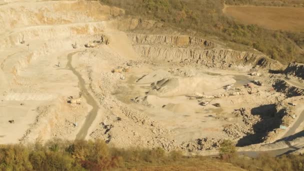 Top view of working quarry. Shot. Sand pit with escalators and buldozeri in open woodland. Mining concept — Stock Video