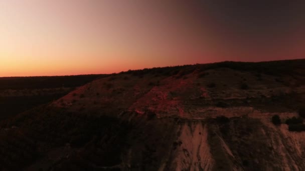 Ovanifrån av hill i röd skymning i kvällsljus. Skott. Pittoreska horisont av röda solnedgången från toppen av kullen. Naturliga landskapet vid solnedgången — Stockvideo