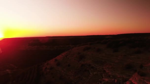 Вид зверху на пагорб у червоні сутінки вечірнього світла. Постріл. Мальовничий горизонт червоного заходу сонця з вершини пагорба. Вид зверху на гору до сусідньої автомагістралі — стокове відео