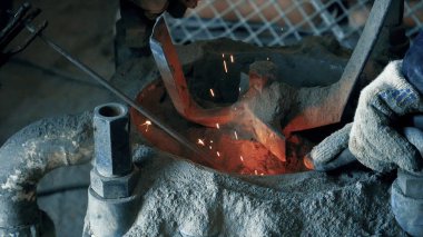 Yakın çekim elektrot kaynak. Çerçeve. Kaynakçı köpüklü elektrot maşa holding ile çalışır. Kaynakçı elektrot güvenli beton kazan içinde çalışır