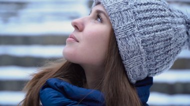 Kış göğe bakarak profil kadında. Rüya gibi bakışla genç çekici kadın