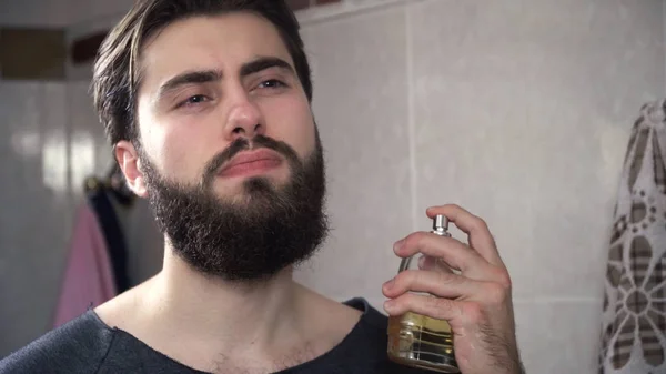 L'homme éclabousse le parfum. Gros plan bel homme sérieux éjacule parfum sur le cou. Homme dans la salle de bain devant miroir preening avant date — Photo