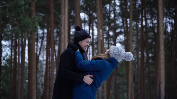 Pareja joven abrazándose y besándose en el parque en invierno. Una pareja feliz juntos. Retrato de feliz encuentro pareja enamorada y beso de brazos largamente esperado —  Fotos de Stock