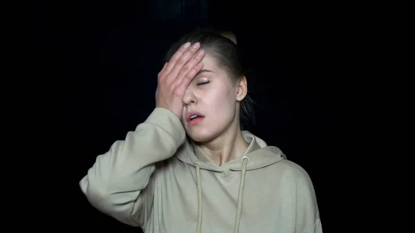 Mujer joven y cansada cubriendo la cara con la mano. Jovencita infeliz e irritada. Expresiones faciales y emociones humanas —  Fotos de Stock