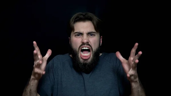 Wütend auf einen jungen Mann mit Bart. Wütender junger Mann mit Bart, der vor Wut seine Zähne knurrend zeigt. menschliche Mimik und Emotionen — Stockfoto