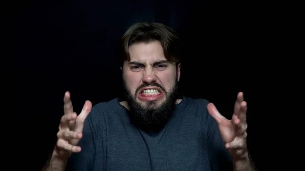Angry of young man with beard. Angry young man with beard, showing his teeth growling in anger. Human facial expressions and emotions — Stock Photo, Image