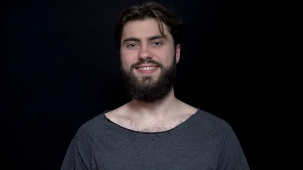 Winking young man with beard showing thumb up. Cheerful man approvingly winks and shows his thumb up. Human facial expressions and emotions — Stock Photo, Image