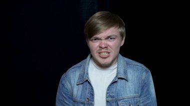 Hırıltı genç adam. Güçlü tahriş ve hırıltı genç adam. İnsan yüz ifadeleri ve duyguları izole siyah arka plan üzerinde