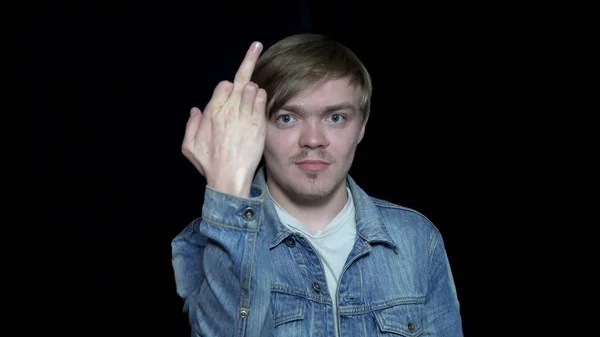 Junger Mann zeigt Mittelfinger. Geste fuck you. junger Mann mit Pokergesicht zeigt Zeichen fuck. Handgesten — Stockfoto