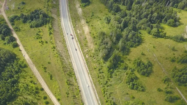 Route de campagne entourée d'une nature verdoyante. Clip. Vue du dessus de la route rurale en forêt. Trafic sur les routes rurales — Photo