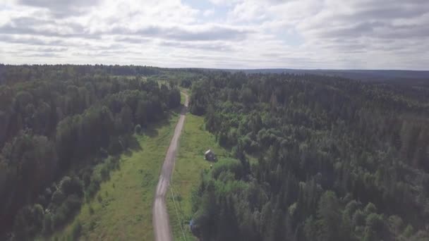 森と雲の空地平線の農村道路の平面図です。クリップ。田舎道の隣の森の小さな家。都市の外の森に隠遁生活 — ストック動画
