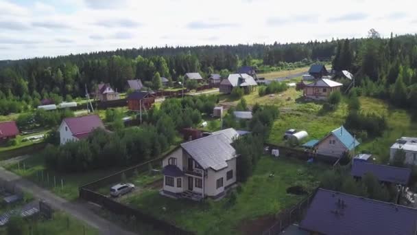 Vista superior de áreas suburbanas com casas na floresta. Clipe. Vida tranquila e moderada em terreno florestal — Vídeo de Stock