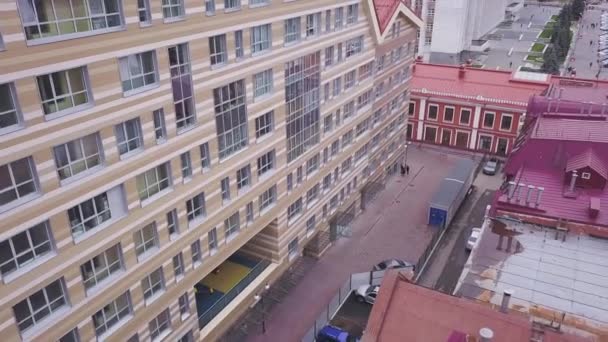 View at windows of business buildings and red roof. Clip. Top view of modern office building with red roof in cloudy weather — Stock Video