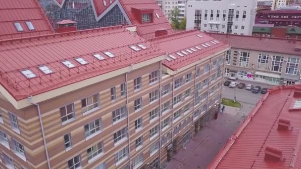 Blick auf Fenster von Geschäftsgebäuden und rotes Dach. Clip. Blick von oben auf modernes Bürogebäude mit rotem Dach bei trübem Wetter — Stockvideo