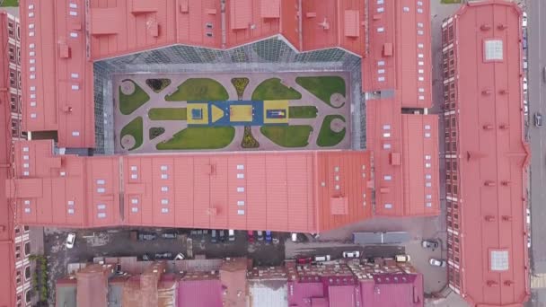 センターのオープン スペースと建物の平面図です。クリップ。U 字型の平面図を閉じた複雑な赤い屋根の建物 — ストック動画