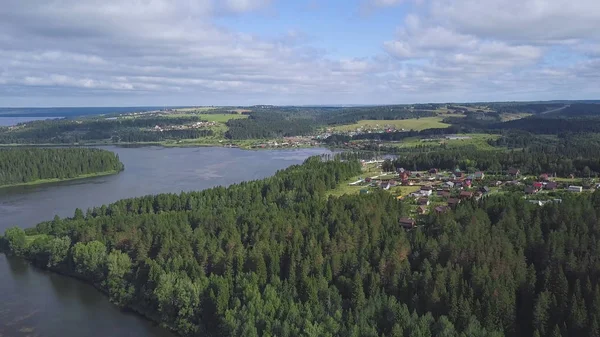 Blick von oben auf Häuser am Seeufer im Wald. Clip. Ruhe und Abgeschiedenheit. Urlaub außerhalb der Stadt. Ferienhäuser mit Parzellen in Stadtnähe am See im Wald — Stockfoto