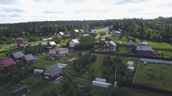 Blick von oben auf Dorf im Wald. Clip. vom Dorfhaus kommt man zu Fuß. Dorfleben mit modernen Hütten im Wald — Stockfoto