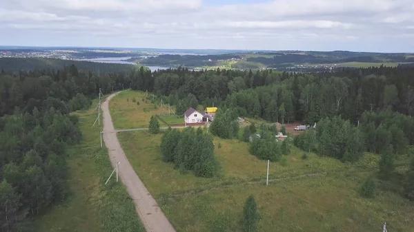Üstten görünüm köy yolu ve orman evde. Küçük. Gözlerden uzak ülke gören orman manzarası. Göl kıyı kenti peyzaj