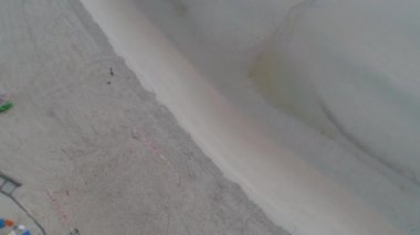 Havadan görünümü şaşırtıcı Beach Voleybol net ve kumun üzerinde yürüyen insanlar. Vurdu. Güzel bir plaj ve Karayip Denizi üstten görünüm.