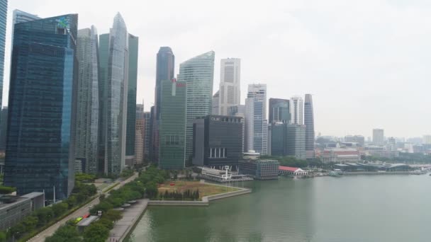 Центральный район Сингапура с небоскребами на берегу реки. Выстрел. Сингапурский ландшафт и деловые здания у реки . — стоковое видео